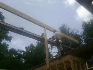 Carpenter setting a ridge beam over a new addition frame — Ice Dam Removal by Roofing Brothers in Mount Carroll
