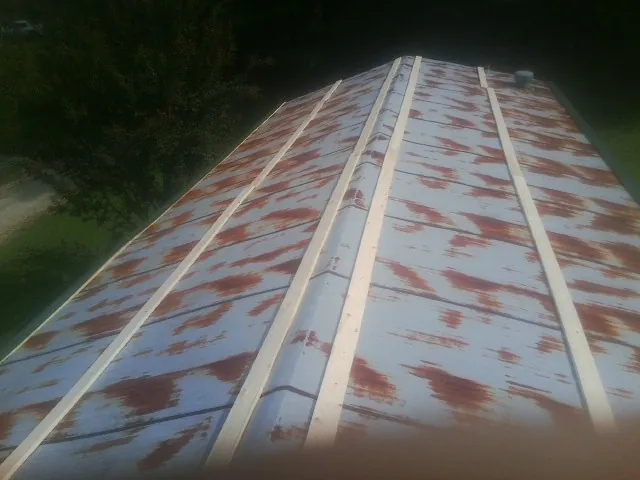 Rusted metal roof panels with new wood purlins before replacement — Storm Damage Roof Repair in Mount Carroll by Roofing Brothers
