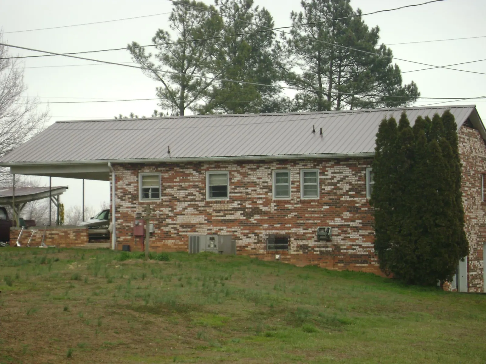 Gray metal roof on a brick split level home with a carport in Mount Carroll