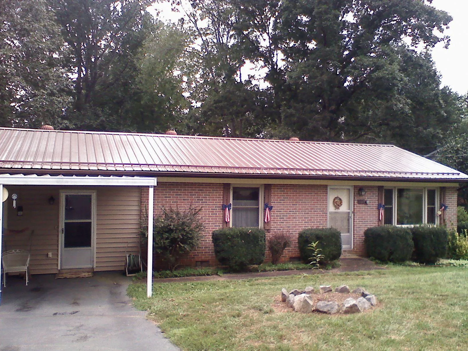 Bronze metal roof and carport on a brick ranch home — Roof Repair work by our crew in Mount Carroll